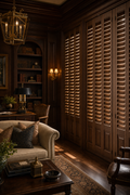 Floor-to-ceiling solid walnut plantation shutters in a richly appointed home library